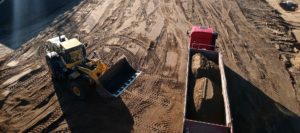 Radlader befüllt LKW mit Sand